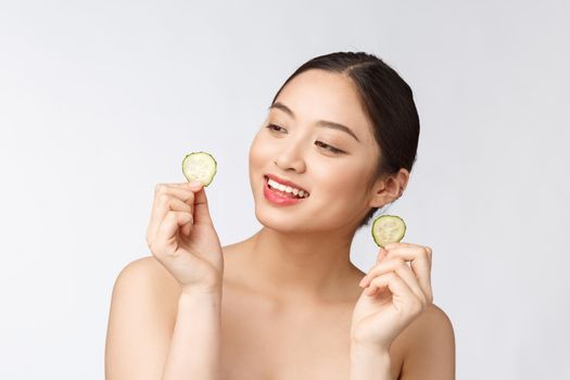 Natural homemade fresh cucumber facial eye pads facial masks. Asian woman holding cucumber pads and smile relax with natural homemade.