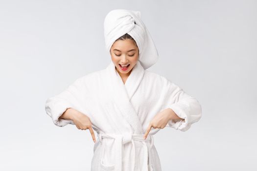 Beauty portrait of young woman showing and pointing finger to empty copy space, asian beauty in bathrobe