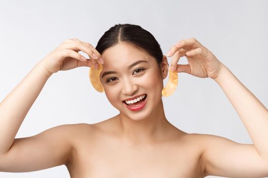 Asian beauty teenager woman care her skin with gold eye masks patches under eyes.