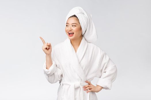 Beauty portrait of young woman showing and pointing finger to empty copy space, asian beauty in bathrobe