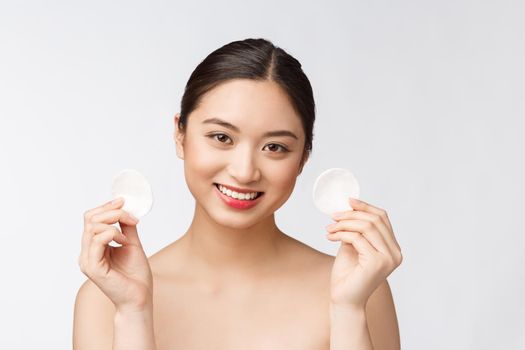 skin care woman removing face makeup with cotton swab pad - skin care concept. Facial closeup of beautiful mixed race model with perfect skin