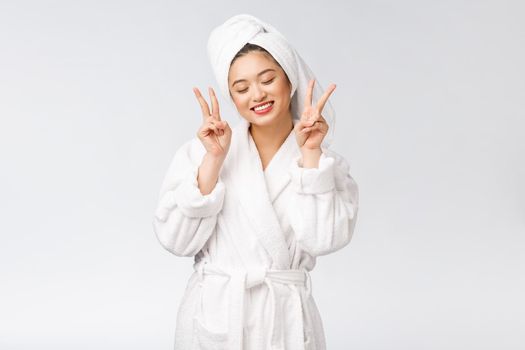 Beautiful asian woman showing peace sign or two finger with happy feeling. Isolated over white background