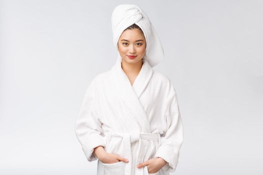 Portrait of a young happy asian lady in bathrobe.Isolated in white background