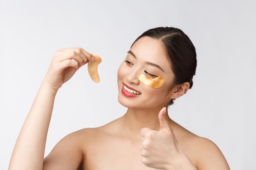 Asian beauty teenager woman care her skin with gold eye masks patches under eyes.