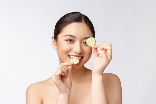 Natural homemade fresh cucumber facial eye pads facial masks. Asian woman holding cucumber pads and smile relax with natural homemade.