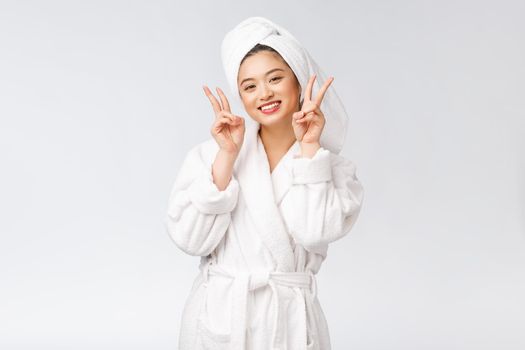 Beautiful asian woman showing peace sign or two finger with happy feeling. Isolated over white background