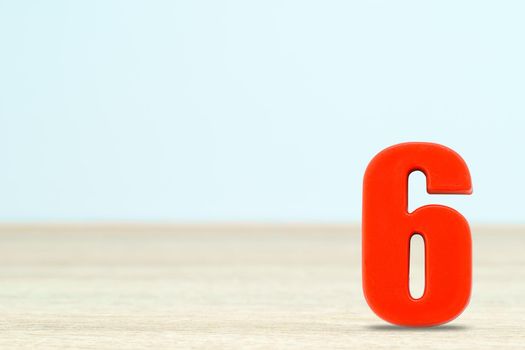 Shot of a number six made of red plastic on table with copy space