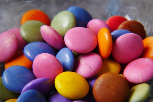 multi-colored sweet candies in a bowl close up .