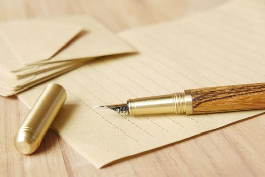 envelope , empty paper and fountain pen on table .