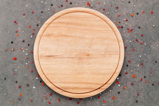 Empty pizza platte with spices set up on dark concrete background flat lay and copy space.