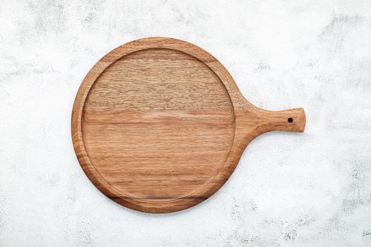 Empty wooden pizza platter set up on white concrete. Pizza board on white concrete background flat lay and copy space.