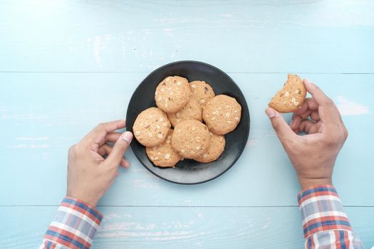 young man eating whole meal cookies .