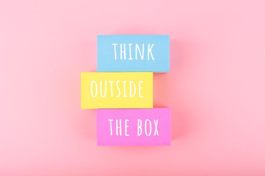 Concept of idea, creativity, start up or brainstorming. Creativity concept. Think outside the box written on colorful rectangles on bright pink background