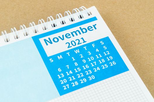 Close up November 2021 desk calendar on brown background.