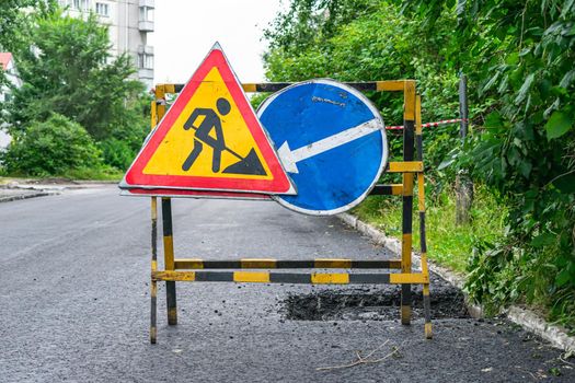 Road signs warning about repair work and laying of new asphalt