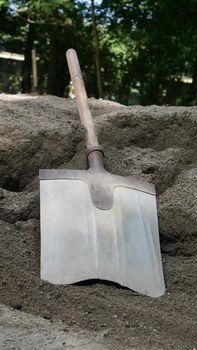 The shovel for dripping is lying on the pile of dry concrete or cement, construction and development concept.