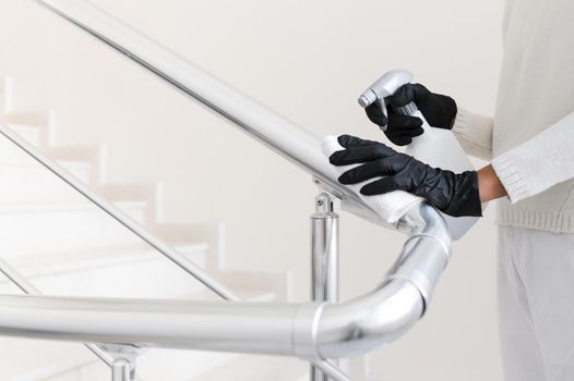 hands with gloves disinfecting hand rail. Resolution and high quality beautiful photo
