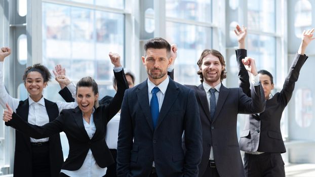 Business winners team. Group of happy people in formal wear celebrating, gesturing, keeping arms raised and expressing positivity