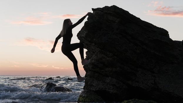 long shot woman climbing rock ocean. Resolution and high quality beautiful photo