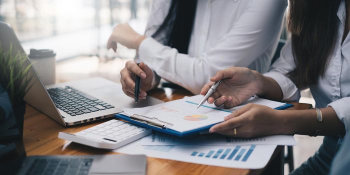 Analytics intelligence concept. Group of business people discuss current financial and economic on laptop for investment at the meeting.