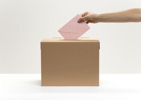 hand puts pink envelope into vote box. Resolution and high quality beautiful photo