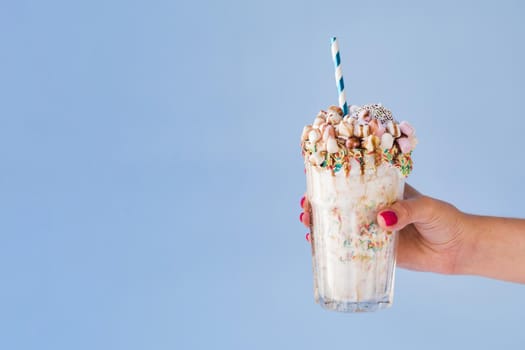 front view hand holding milkshake with blue background. Resolution and high quality beautiful photo