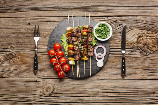 delicious meat skewer black slate with fork butter knife wooden table. Resolution and high quality beautiful photo