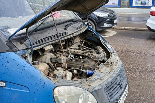 Fragment of a minibus with a raised hood, the device of the engine compartment. Car device