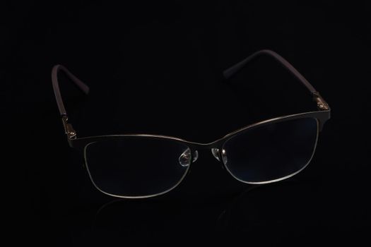Glasses in fashionable frames on a black background. Close up
