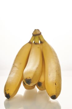 Bunch of ripe yellow bananas on white background. Close up, vertical shot