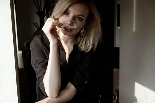 Close-Up Of Young Woman Smoking Cigarette By Window