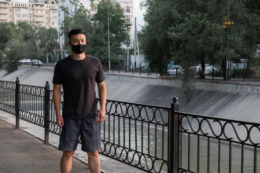 An Asian man preparing for running in the city, in the evening. Kazakhstan