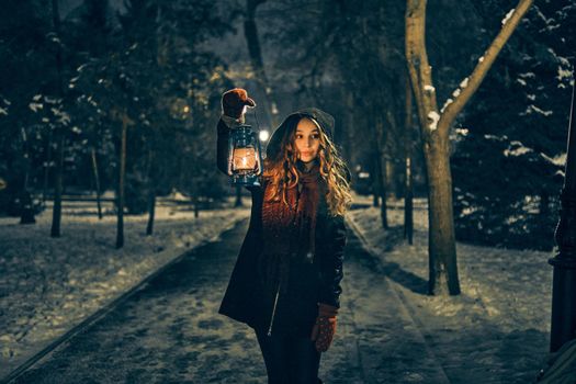 Young girl with lantern in winter forest fairy tale, book cover, christmas time