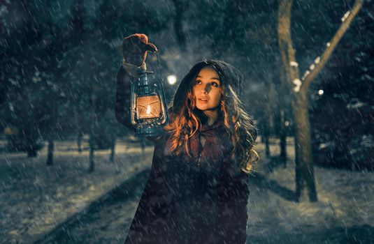 Young girl with lantern in winter forest fairy tale, book cover, christmas time