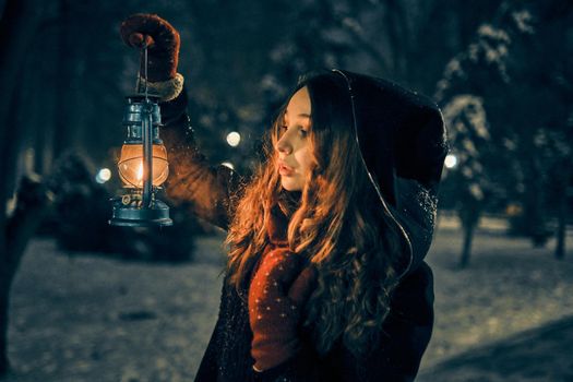 Young girl with lantern in winter forest fairy tale, book cover, christmas time