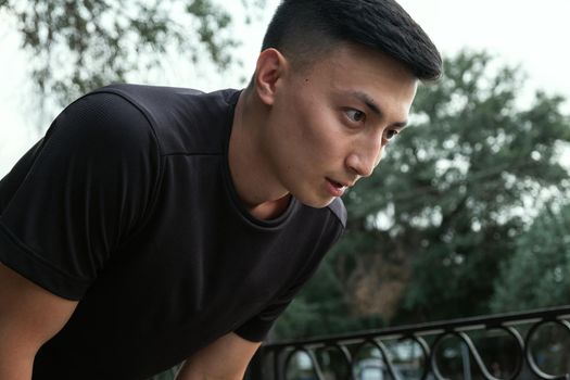 Shot of a handsome young man taking a moment to catch his breath after a morning run in the city