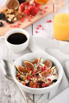 Healthy and delicious breakfast. Oatmeal muesli with Greek yogurt, fresh figs, dried fruits and pomegranate.