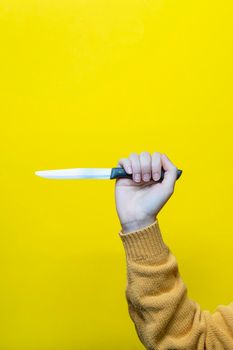 a female hand with the knife pointed