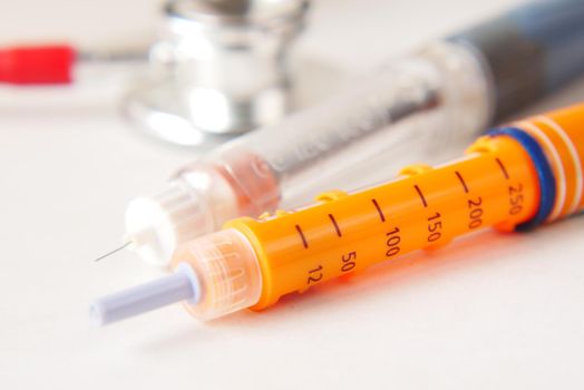 Insulin pens on wooden background, close up .