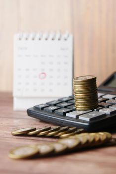 stack of coins and calendar on white background .