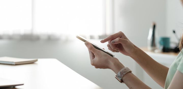 Close up hand of woman using phone, browsing apps, reading good news in message, happy young female chatting or shopping online, having fun with gadget