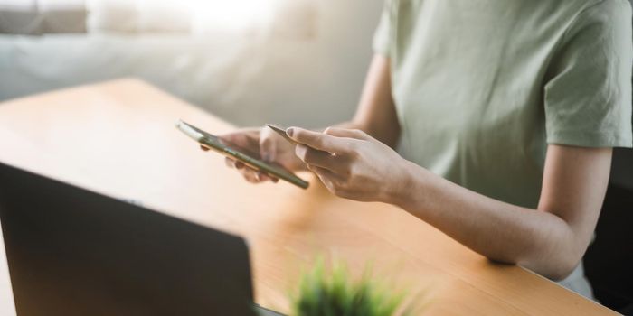 Close up hand of woman using credit card and mobile phone for online shopping and internet payment via mobile banking app