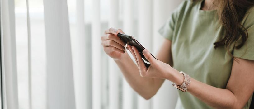 Close up woman hand holding smartphone, Girl using mobile phone at home.