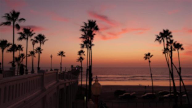 Blurred palms silhouette, twilight sky, California USA, Oceanside pier. Dusk gloaming nightfall atmosphere. Tropical pacific ocean beach, sunset afterglow aesthetic. Dark palm tree, Los Angeles vibes.