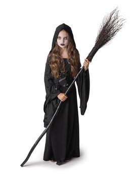 Portrait of little girl in black cloak clothing with broom on white background, Halloween witch costume, studio isolated on white background