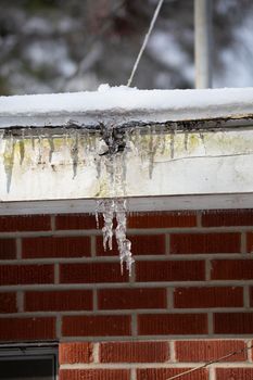 Large icicles hanging from a red brick house