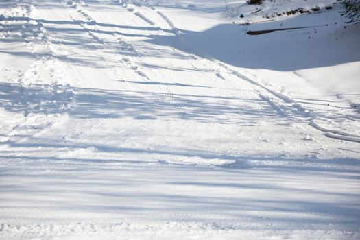 Shallow tire tracks on a dangerous snow-covered road