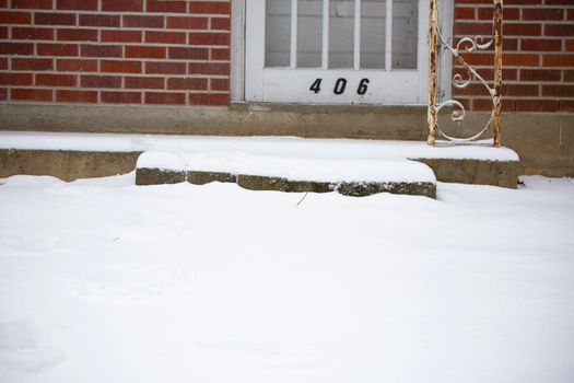 White snow on a yard and a slightly raised porch