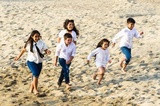 Children running along the shore of the beach a sunny day