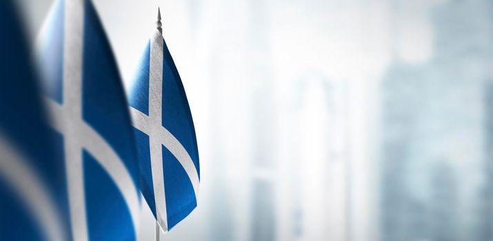 Small flags of Scotland on a blurry background of the city.